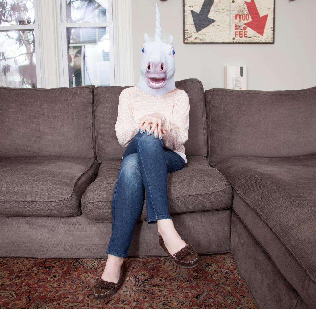 Girl-sitting-on-sofa-wearing-unicorn-hea
