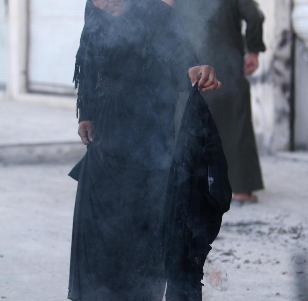 A-woman-sets-fire-to-a-niqab-after-she-w