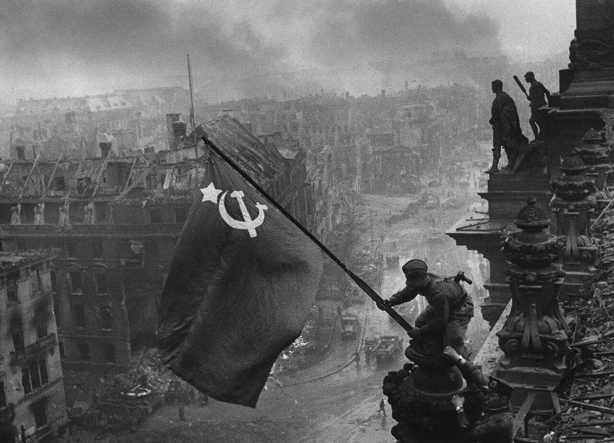 1280px-Raising a flag over the Reichstag